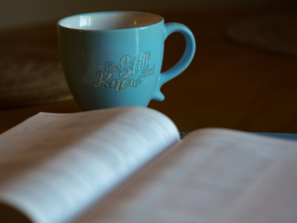 Bible open with coffee mug